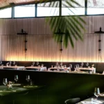 Grande salle lumineuse du restaurant Maison B à Bridel avec tables dressées pour le déjeuner.