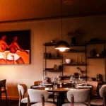 Salle intime aux touches arty et table ronde chaleureuse au restaurant Maison B à Bridel.