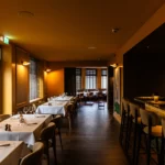 Espace bar contemporain et l'espace restaurant à l'intérieur de la brasserie Maison B à Bridel.