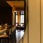 Détail du comptoir de bar et des tabourets design au restaurant Maison B à Bridel.