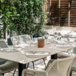 Table dressée pour un déjeuner au vert sur la terrasse arborée de la brasserie Maison B à Bridel.